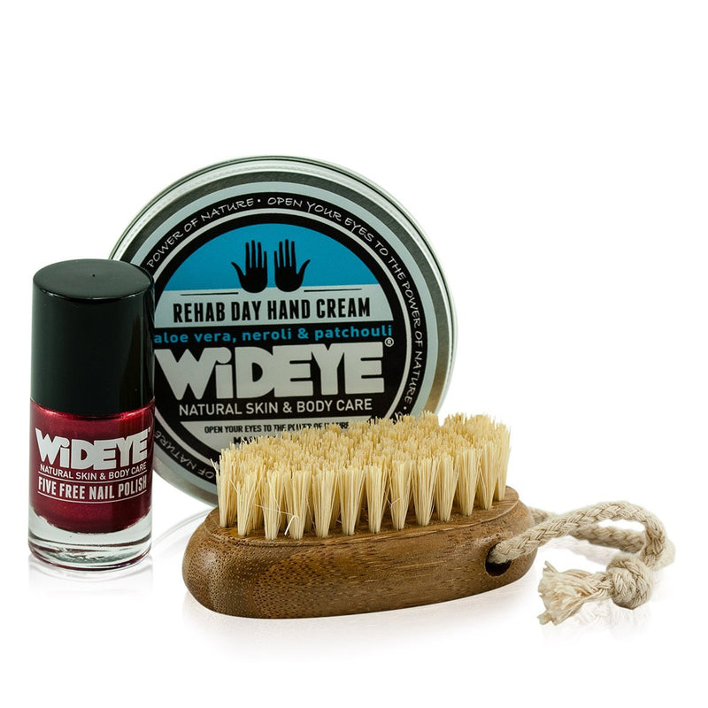 Natural wooden nail brush with coconut bristles, placed next to WiDEYE Rehab Day Hand Cream and WiDEYE Fire Storm Nail Polish.